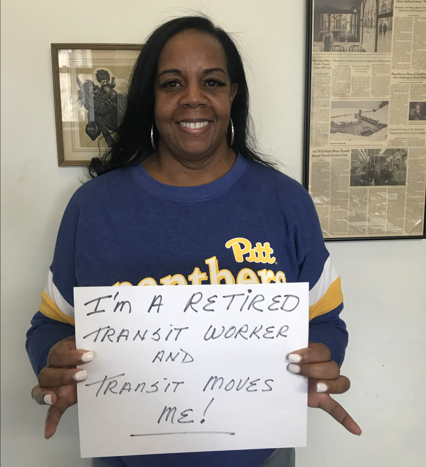 A person holding a sign reading "I'm a retired transit worker and transit moves me!"